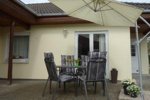 卡尔斯哈根Heydens Ferienhaus_HEYD的庭院里配有桌椅和遮阳伞