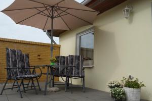 卡尔斯哈根Heydens Ferienhaus_HEYD的庭院内桌椅和遮阳伞