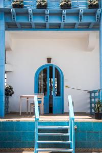 达哈布达哈布艾尔普里莫酒店的大楼内带桌椅的蓝色门
