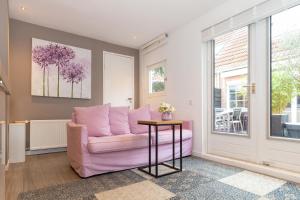 阿姆斯特丹Bed & Bike Studio Amsterdam的客厅配有粉红色的沙发和桌子