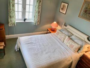 特鲁罗Jago Cottage的卧室配有一张大白色床和窗户