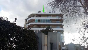 丰沙尔Bright Studio的一座高大的建筑,上面有绿色的箭头