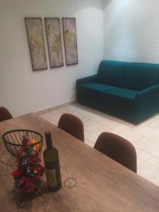 斯韦蒂·斯特凡Villa Edelweiss的一间设有一张桌子、一瓶葡萄酒和一张蓝色沙发的客房