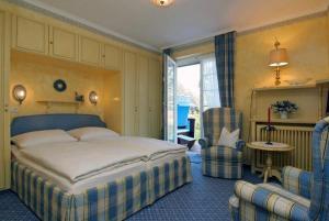 文尼斯塔特Hotel Wiesbaden的一间卧室配有一张大床和两把椅子