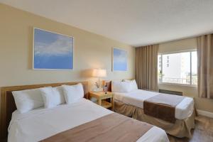 克利尔沃特The Beachview Inn Clearwater Beach的酒店客房设有两张床和窗户。