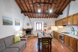 卡斯蒂戈隆·多尔希亚Agriturismo Il Poderuccio的厨房以及带桌子和沙发的客厅。