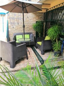 圣何塞Casa Leon Guesthouse的庭院配有桌椅和遮阳伞。