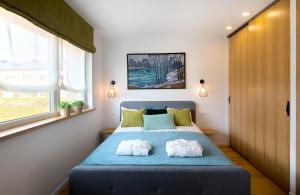 维尔纽斯Brand new modern townhouse的一间卧室配有蓝色的床和两个枕头