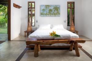圣米格尔-杜斯米拉格里斯Pousada da Amendoeira的一间卧室配有一张床和一张木桌