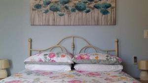 圣保罗湾城Comfort Apartment No. 16, Daffodil Court的一张带两个枕头的床和一张墙上的照片