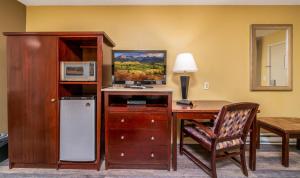 HotchkissHotchkiss Inn Motel的客房设有带微波炉和冰箱的书桌。