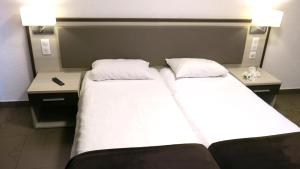 卢尔德朝圣者公寓式酒店的两间双床间位于带两张桌子的酒店客房内