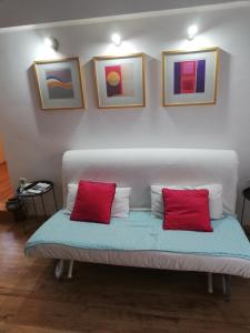 卡什泰拉Dvor Ana的一张沙发,里面配有两个红色枕头