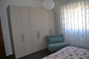 诺利Cà da Lalla Maria的一间卧室配有一张床和一张蓝色椅子