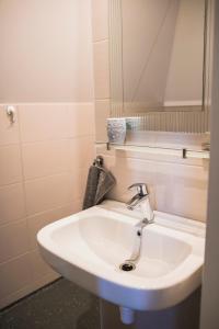哈伦B&B Lisa Groningen的浴室设有白色水槽和镜子