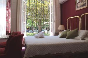 科洛尼亚-德尔萨克拉门托格贝纳多尔酒店的一间卧室设有一张床和一个大窗户