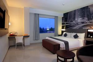 三宝垄Hotel Neo Candi Simpang Lima - Semarang by ASTON的酒店客房设有一张床和一个大窗户