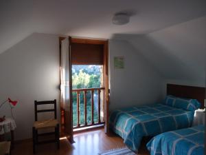 安索Casa Úrsula的一间卧室设有一张床和一个阳台的窗户。