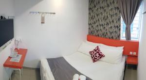 关丹Tas 96 Inn的一间卧室配有一张带红色床头板的床和一张书桌