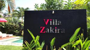 坎古Villa Zakira的游泳池前读别墅zaza的标志