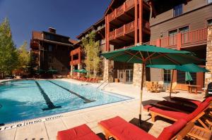 阿斯潘The Ritz-Carlton Club, 3 Bedroom Residence 8216, Ski-in & Ski-out Resort in Aspen Highlands的酒店旁的游泳池配有椅子和遮阳伞