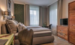 施塔恩贝格斯塔尔恩贝尔格希酒店的一间卧室配有一张床、一台电视和一张书桌