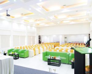 特尔纳特岛Emerald Hotel的配有绿色和黄色椅子和桌子的房间