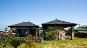 济州市蓬蓬度假屋的一间黑色屋顶的小房子