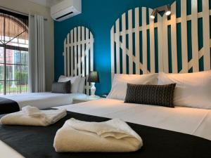 古尔本古尔伯恩文化遗产汽车旅馆的卧室设有两张床铺和蓝色的墙壁