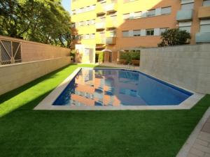 巴塞罗那城市海滩公寓酒店的一座游泳池,位于一座建筑旁的院子内