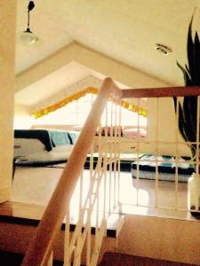 大雅台Tagaytay Budget Transient/ Staycation Home的楼梯通往卧室,卧室配有床
