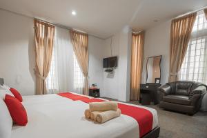 巴淡岛中心RedDoorz @ Batam Center 2的一间卧室配有一张床、一把椅子和电视