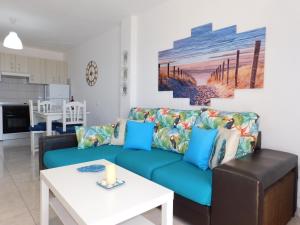 大塔拉哈尔Sol y Mar Gran Tarajal 3 Planta的客厅配有蓝色的沙发和桌子