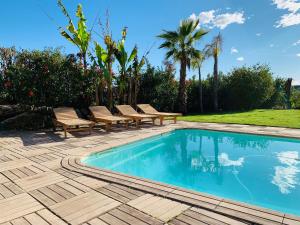拉戈德Villa Angel的一个带长椅和树木的游泳池以及庭院