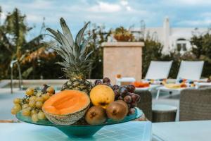 阿纳卡普里艾穆利尼奥酒店的坐在桌子上的一碗水果
