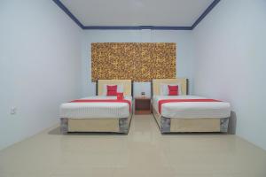 巴淡岛中心RedDoorz Near RSUD Embung Fatimah Batam的白色地板的客房内设有两张单人床。