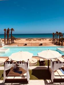 圣玛丽亚Hotel LIVVO Budha Beach的一个带两把遮阳伞的游泳池和一个海滩