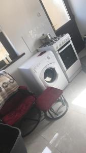 贝尔马利特The West House的客房内的洗衣机和椅子