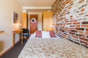 萨翁林纳罗西兰塔旅舍的一间设有砖墙和床的酒店客房