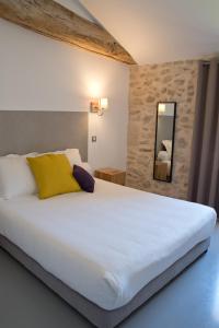 索泰尔纳Hôtel Le 23的卧室配有一张白色大床和黄色枕头