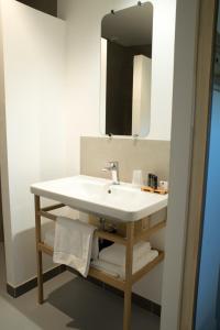 索泰尔纳Hôtel Le 23的浴室设有白色水槽和镜子