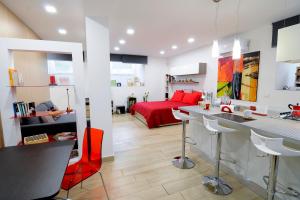 皮亚扎-阿尔梅里纳Folco Studio Apartment的一间厨房和一间带红色床的客厅
