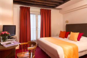 巴黎圣罗奇酒店的酒店客房配有一张床、一张书桌和一台电视。