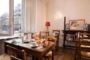 巴黎隆德雷斯圣诺里酒店的一间带桌椅和窗户的用餐室
