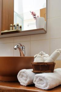 扎戈拉卡帕尼阿里斯公寓式酒店的一间带水槽和一篮毛巾的浴室