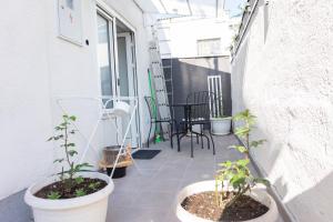 萨格勒布Apartman Zagreb Maksimir的阳台种植了盆栽植物,配有桌椅