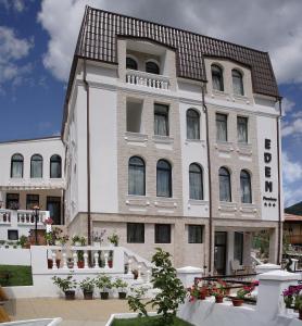 百乐·奥拉内斯蒂Pensiunea Eden的白色的大建筑,带有棕色的屋顶