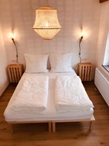腓特烈港Charmantes Loft mit ganz besonderem Flair的一张带白色床单和枕头的床