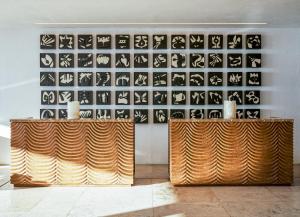 圣何塞德尔卡沃洛斯卡沃斯总督度假村的一间房间,墙上有两张木桌,墙上有艺术作品