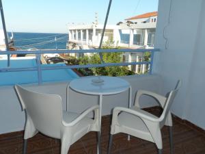 希俄斯海滨一室公寓和公寓的阳台配有一张桌子和两把椅子,享有海景